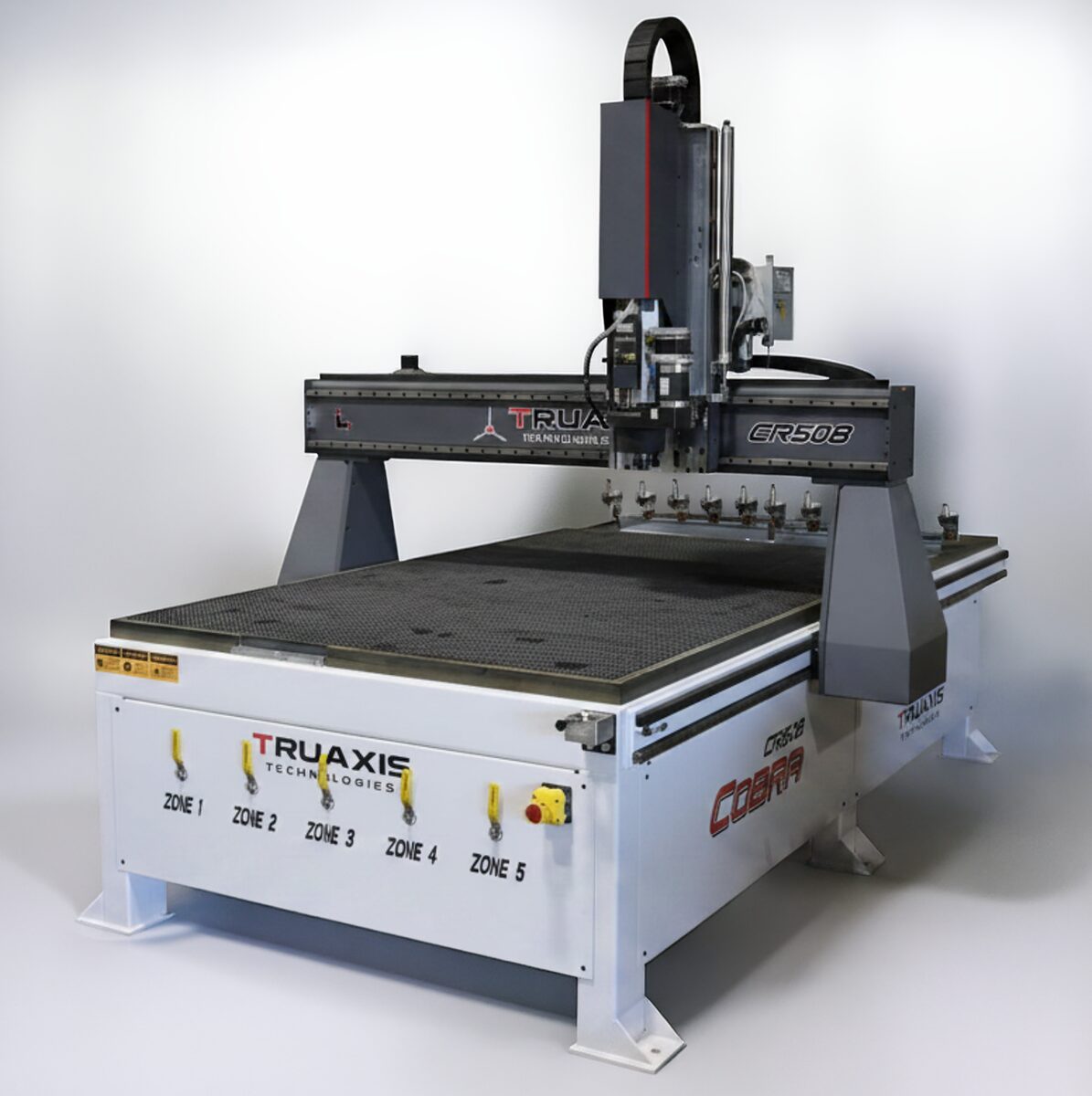 TruAxis Cobra CNC router seen from the front left, with a heavy bridge gantry, tool rack and five-zone vacuum table.